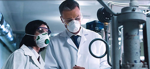Photo of two scientists wearing masks.