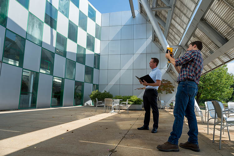Researchers monitor the exterior of a building.